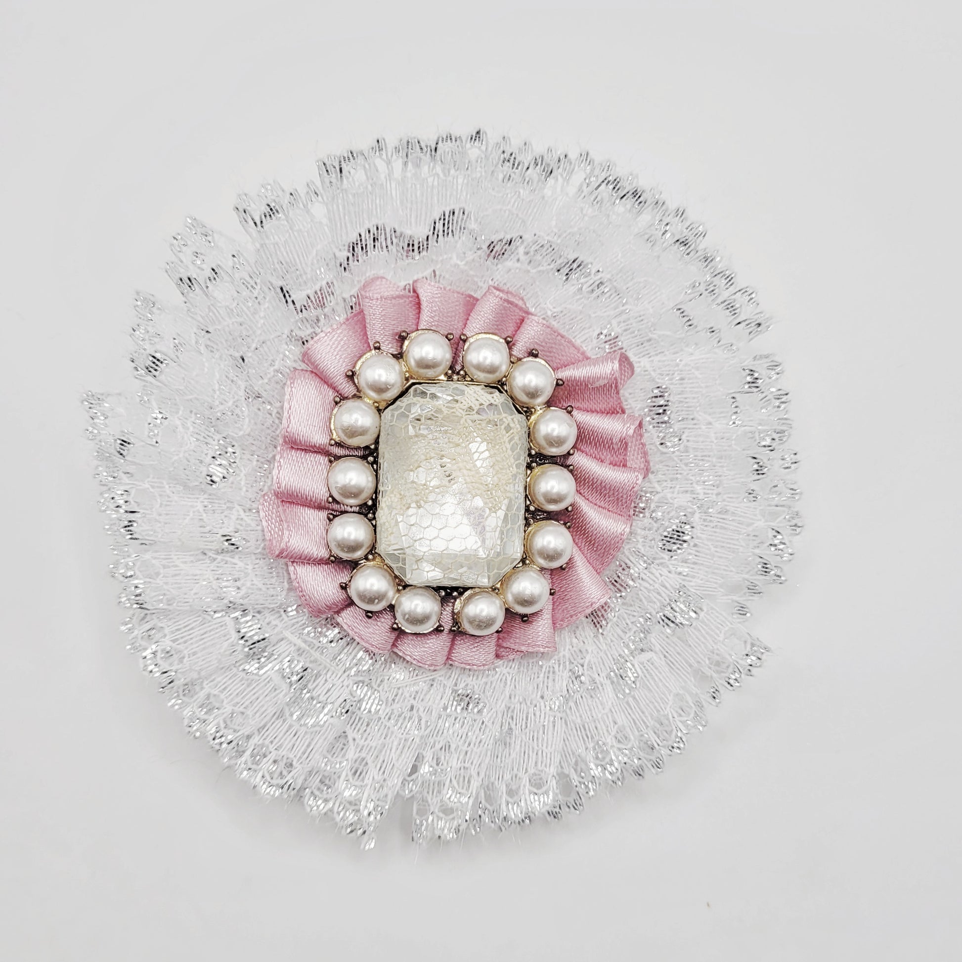 White and pink lolita brooch with shiny gem insert encrusted with pearls.