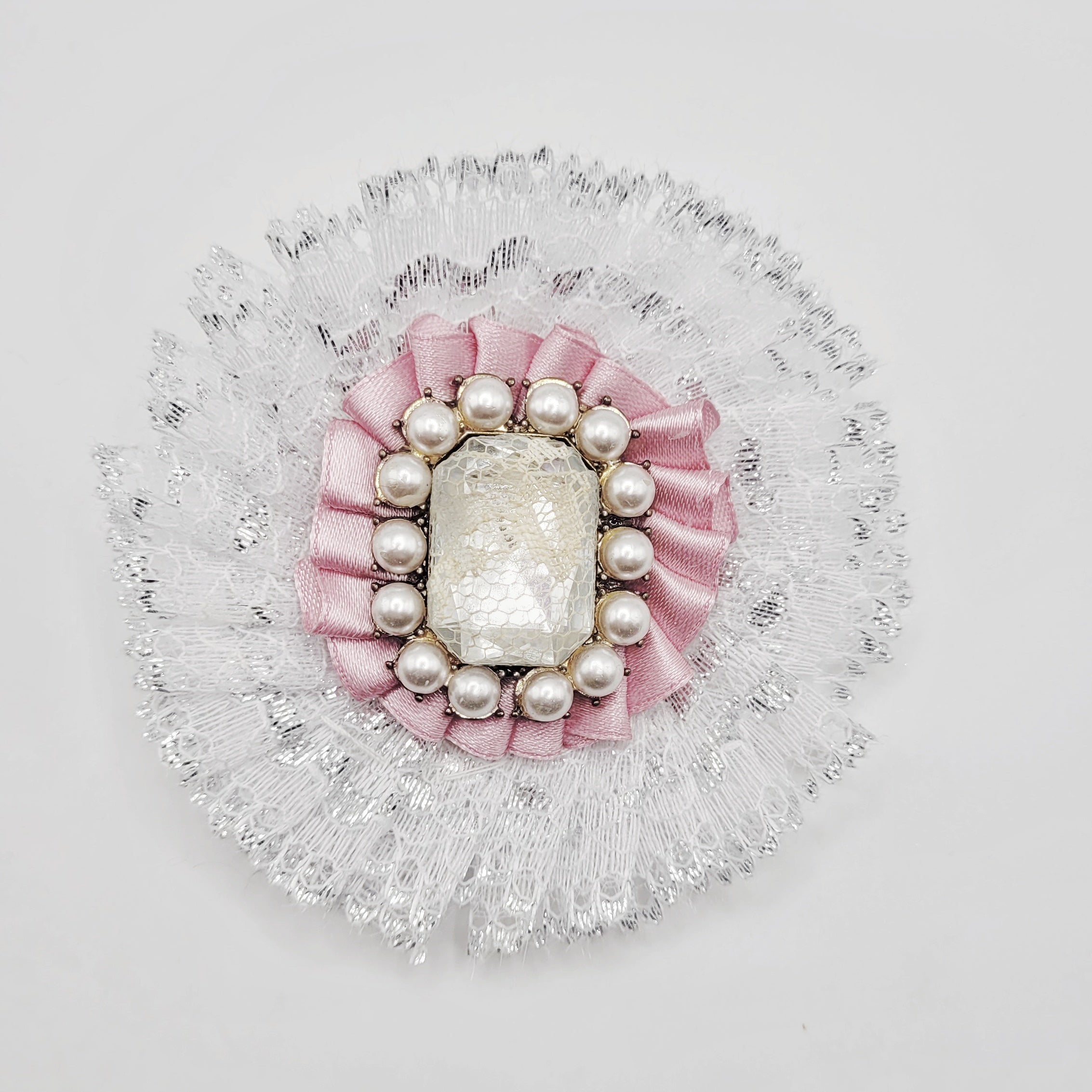 White and pink lolita brooch with shiny gem insert encrusted with pearls.